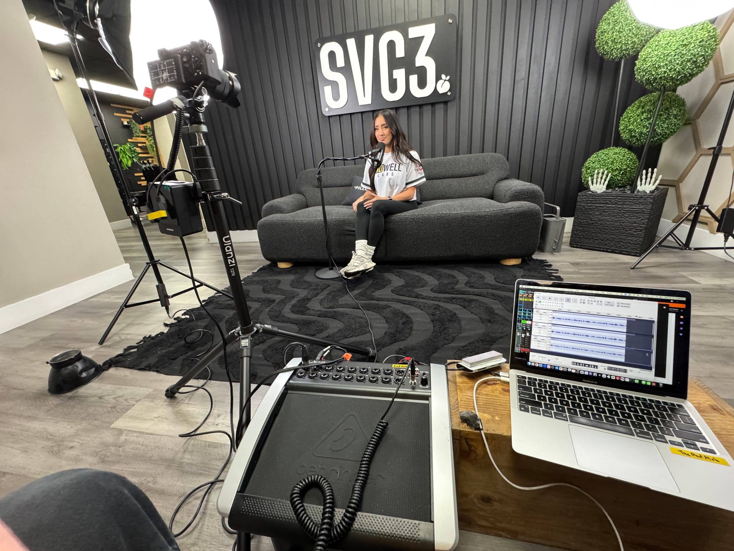 Behind the cameras at an office shoot, with the mixer and laptop in front of the set
